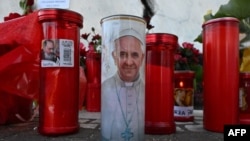 Se colocan velas en la estatua de Juan Pablo II afuera del Hospital Universitario Gemelli, donde el Papa Francisco está hospitalizado con neumonía, en Roma, el 3 de marzo de 2025.