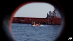 FILE - In this Wednesday, Aug. 30, 2017 file photo, rescuers transfer migrants rescued by an oil rig supply ship to the Aquarius vessel of SOS Mediterranee and MSF (Doctors Without Borders) NGOs, in the Mediterranean Sea, north of Libyan coast.