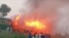 People watch fire burning a train after a gas canister passengers were using to cook breakfast exploded, near the town of Rahim Yar Khan in the south of Punjab province, Pakistan, Oct. 31, 2019, in this still image take from video. 
