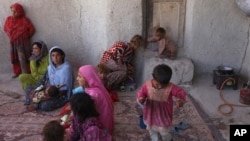 In this May 30, 2016, photo, members of an internally displaced Afghan family are seen at their temporary home in a camp for displaced people in Kabul, Afghanistan.