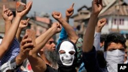 Masked Kashmiri protesters hold bricks as they shout freedom slogans in Srinagar, India, May. 27, 2017. One civilian was killed and dozens of others injured Saturday after massive anti-India protests and clashes erupted in Indian-controlled Kashmir following the killing of a prominent rebel commander and his associate.