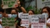 Health workers wearing protective masks carry placards as they hold a protest in front of a government hospital in Manila on February 7, 2020. - The new coronavirus that emerged in the Chinese city of Hubei to date has killed more than 630 people,…