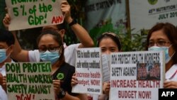 Health workers wearing protective masks protest in front of a government hospital in Manila, Feb. 7, 2020. The Philippines, Feb. 2, reported the first death from the new coronavirus outside mainland China.