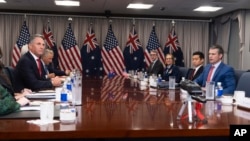 Defense Secretary Pete Hegseth, right, welcomes Australian Deputy Prime Minister and Defense Minister Richard Marles, left, before the start of their meeting at the Pentagon, Feb. 7, 2025, in Washington.