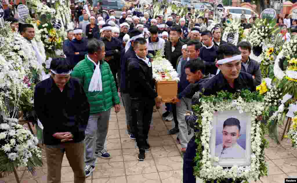 Relatives of John Hoang Van Tiep, a victim who was found dead in the back of a British truck last month, carry his coffin to a church for his funeral in Nghe An province, Vietnam.