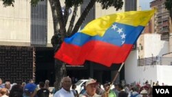 Hombre sostiene una bandera de Venezuela en una protesta de jubilados del país para exigir, de nuevo, pensiones dignas. [Foto: Álvaro Algarra, VOA]