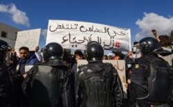 Security forces confront protesters from the Ettadhamen city suburb on the northwestern outskirts of Tunisia's capital Tunis, Jan. 26, 2021.