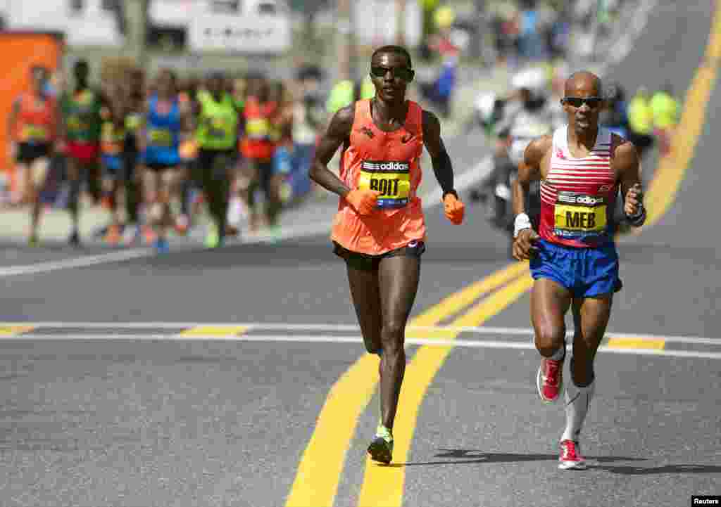 Pelari maraton Josphat Boit (kiri) dan Meb Keflezighi berlomba untuk mencapai garis finish pada lomba maraton di kota Boston, AS.