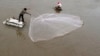 FILE - A man casts a fishing net on the Mekong riverbank in Phnom Penh, Cambodia.