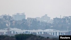 Buildings lie in ruin in Gaza, amid the ongoing conflict between Israel and the Palestinian Islamist group Hamas, as seen from southern Israel, December 13, 2023.