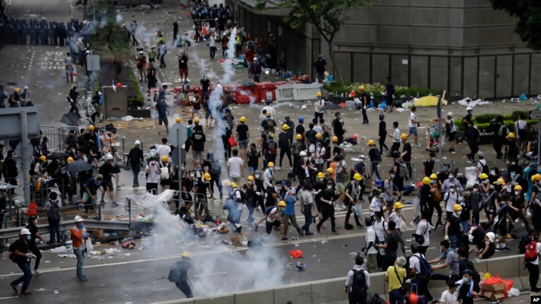 Polisi anti huru-hara menembakkan gas air mata untuk membubarkan pendemo di luar gedung DPR Hong Kong, 12 Juni 2019. 