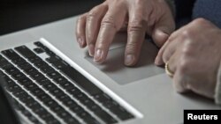 FILE - A cybersecurity expert works on his laptop computer in Charlotte, North Carolina, USA.