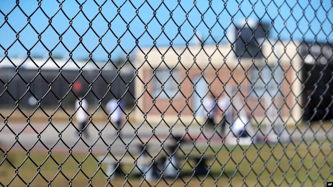 FILE - Detainees sit in a yard during a media tour inside the Winn Correctional Center in Winnfield, La. 
