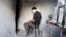 FILE - A blindfolded man waits to be interrogated in a prison in Aleppo, Syria, Oct. 6, 2014. Activists say more than 110,000 detainees are currently being held in Syria, most of them by the government of President Bashar al-Assad.