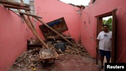 Humberto Cruz stands inside his house destroyed by the earthquake that struck the southern coast of Mexico late on Thursday, in Ixtaltepec, Mexico, Sept. 10, 2017.