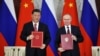시진핑(왼쪽) 중국 국가주석과 블라디미르 푸틴 러시아 대통령이 21일 크렘린궁에서 회담 직후 합의문에 서명해 들어보이고 있다.