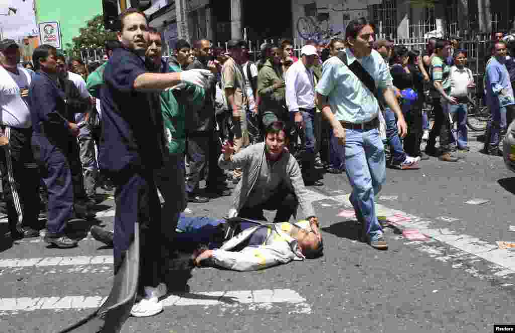 Un hombre herido yace sobre el asfalto en una calle de Bogot&aacute;. El atentado provoc&oacute; la muerte de al menos cinco personas e hiri&oacute; a unas 25.