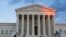 FILE - People stand on the plaza in front of the Supreme Court at sunset, Feb. 13, 2016, in Washington.