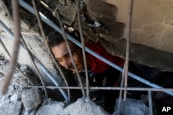 Warga Palestina mencari korban yang masih hidup di bawah reruntuhan gedung-gedung yang hancur akibat serangan udara Israel di kamp pengungsi Khan Younis di selatan Jalur Gaza, Senin, 6 November 2023. (Foto: Mohammed Dahman/AP Photo)