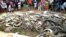 People look at the carcasses of crocodiles slaughtered by villagers in Sorong, West Papua, Indonesia, July 14, 2018.