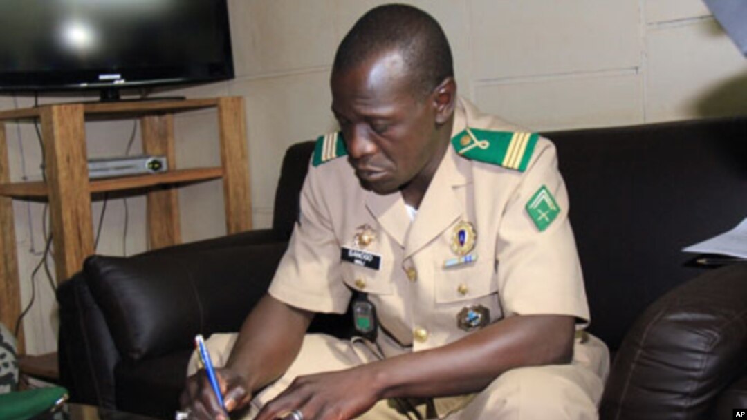 Mali's military junta leader, Captain Amadou Sanogo signs documents as the junta and the West African bloc ECOWAS announced a deal that includes the lifting of sanctions and an amnesty for those involved in last month's coup at the Kati military camp, nea
