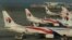 Ground crew work among Malaysia Airlines planes on the runway at Kuala Lumpur International Airport (KLIA) in Sepang, July 25, 2014. 