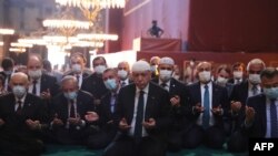 Photo taken on July 24, 2020, by the Turkish Presidential Press service shows Turkey's President Tayyip Erdogan, center, and invited guests attending Friday prayers at Hagia Sophia Grand Mosque in Istanbul. 