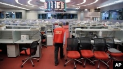 Yip Wing-keung, a trading manager at local brokerage Christfund Securities, wearing his red trading jacket, walks at the Hong Kong Stock Exchange, Oct. 19, 2017.