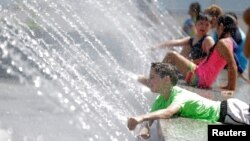 Children play in a fountain during a heat wave in Washington, July 24, 2016. 