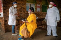 FILE - A South African woman is briefed before taking a COVID-19 test at the Ndlovu clinic in Groblersdal , 200 kms north-east of Johannesburg, Feb. 11, 2021.