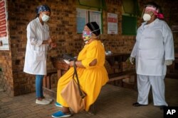 FILE - A South African woman is briefed before taking a COVID-19 test at the Ndlovu clinic in Groblersdal , 200 kms north-east of Johannesburg, Feb. 11, 2021.