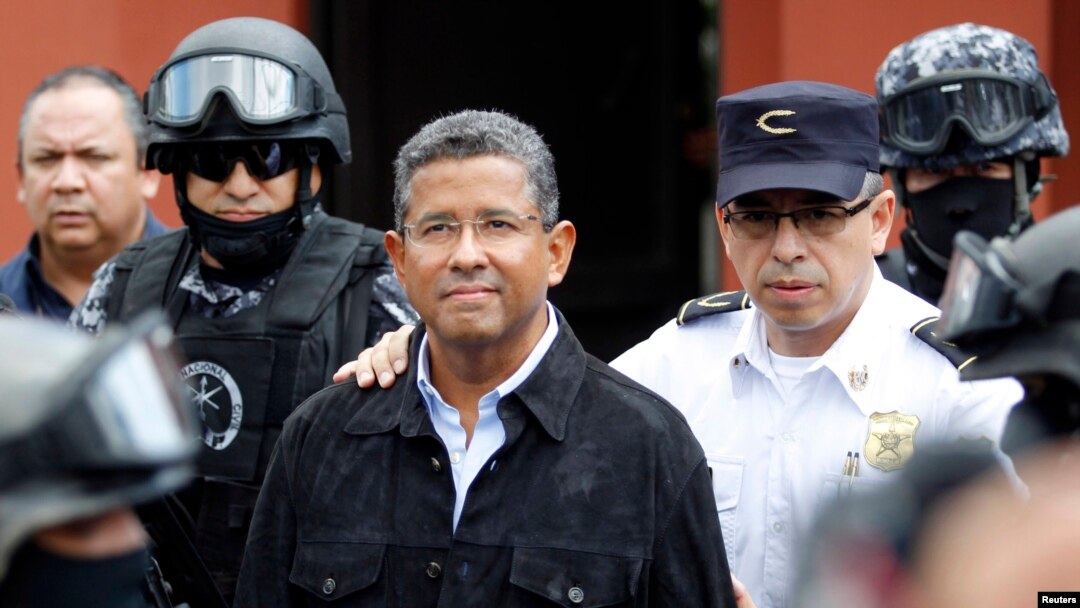 Former El Salvador President Francisco Flores (C) walks out of his house while being guarded by Deputy Director of Police Howard Cotto (R) and the elite unit Reaction Police Group (GRP) in San Benito neigborhood, San Salvador, Sept. 19, 2014.
