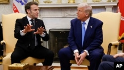 France's President Emmanuel Macron speaks as President Donald Trump listens during a meeting in the Oval Office of the White House in Washington, Feb. 24, 2025.