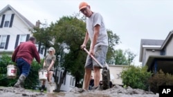 Домовладелец убирает грязь во время ликвидации последствий удара стихии, последовавшего за ослабевшим штормом «Берил». 11 июля 2024 года, в Уотербери, штат Вермонт.
