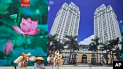 Penjual makanan ringan dan buah menunggu pelanggan di dekat papan iklan pusat perbelanjaan dan gedung apartemen di Kota Ho Chi Minh, Vietnam, 29 April 2015. (Foto: AP)