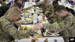 U.S. soldiers pray before eating a Thanksgiving meal at a coalition base dining hall, Kabul, Afghanistan, Nov. 22, 2012. 