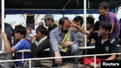 Asylum seekers from Afghanistan, Iraq and Iran cry as Indonesian officers force them to leave the Australian vessel Hermia docked at Indah Kiat port in Merak, Indonesia's Banten province, April 9, 2012. 