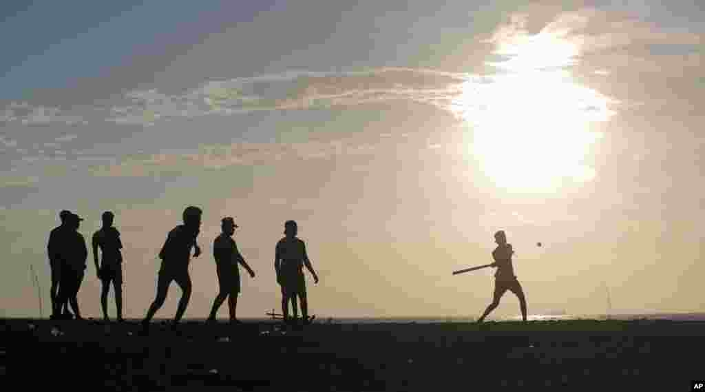 Sri Lankan youths play a game of &quot;Elle,&quot; a local sport similar to baseball, on the sea promenade in Colombo.