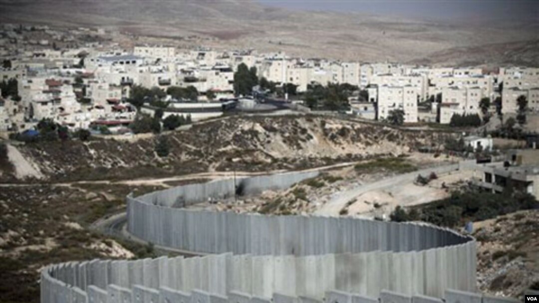 Israel menyetuji pembangunan permukiman baru di kawasan permukiman "Pisgat Zeev" di Yerusalem Timur (atas) yang tampak dilindungi oleh pagar beton pemisah.