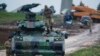 FILE - Turkish soldiers on an armored personnel carrier secure a staging area for troops preparing their tanks to enter combat and join a military offensive on a Kurdish-held enclave in northern Syria, in Hatay province, Turkey, near the the border with 