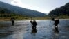 FILE - Naga men are seen walking through a creek in the Naga Self-administered Zone in northwest Myanmar.