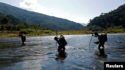 FILE - Naga men are seen walking through a creek in the Naga Self-administered Zone in northwest Myanmar.