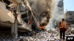 Seorang anggota pertahanan sipil Palestina berdiri di dekat sebuah gedung yang terbakar akibat pemboman Israel di lingkungan Sheikh Radwan di utara Kota Gaza, 3 September 2024. (Foto: AFP)