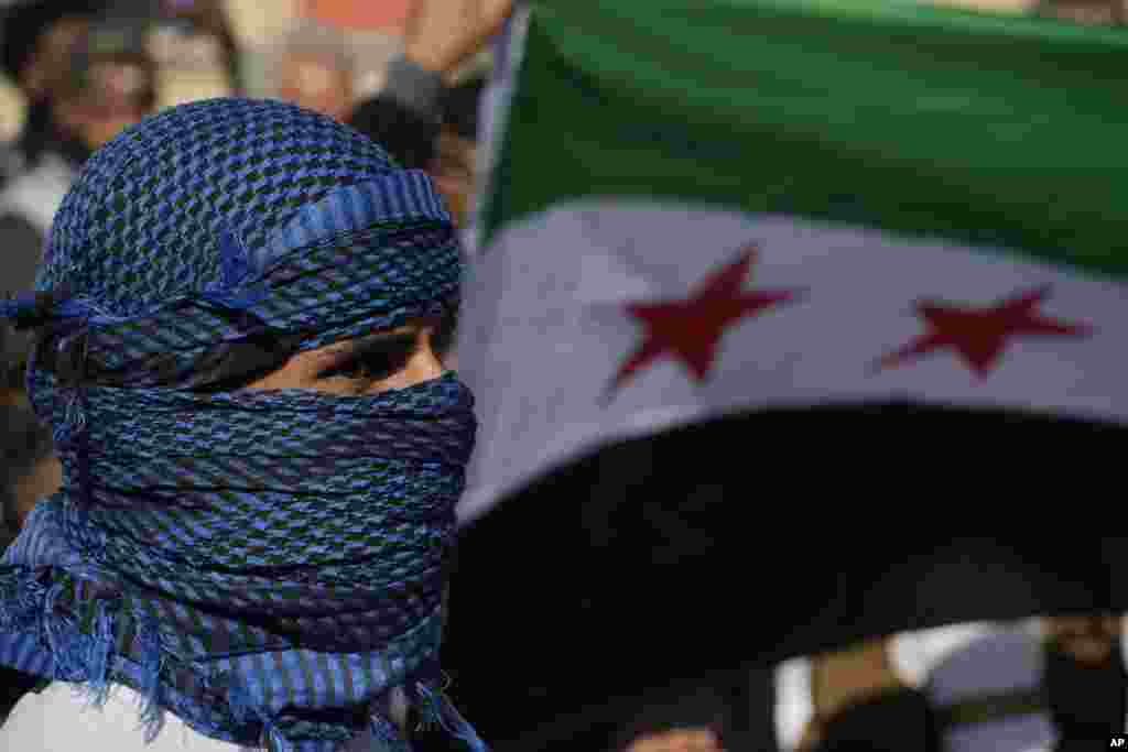 Un hombre sirio se encuentra frente a una bandera durante una manifestación espontánea para celebrar la caída del régimen de Assad en Nicosia, Chipre, el domingo 8 de diciembre de 2024.