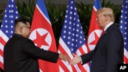 Le dirigeant nord-coréen Kim Jong Un et le président américain Donald Trump sur l'île de Sentosa, Singapour, le 12 juin 2018.