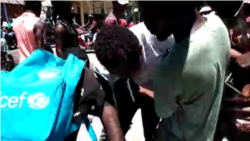 A teen protester who nearly fainted due to hunger is helped up by bystanders.