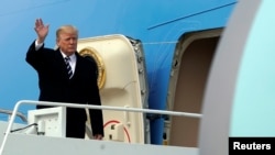 Presiden Amerika Serikat, Donald Trump melambaikan tangannya dari pesawat Air Force One di Bandara Militer Andrews, Maryland, setibanya dari Palm Beach, Florida, 22 April 2018. 