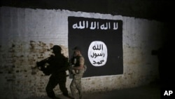 FILE - An Iraqi soldier inspects a former train tunnel displaying the the Islamic State group flag, in western Mosul, Iraq, March 1, 2017. The tunnel once served as a training camp for IS fighters.