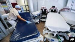 Un trabajador médico limpia camillas en una sala de emergencias en Nueva York, durante un repunte de casos de coronavirus.