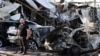 FILE - A man inspects site of car bomb explosion in Baghdad's eastern Mashtal neighborhood, Iraq, Nov. 17, 2014.